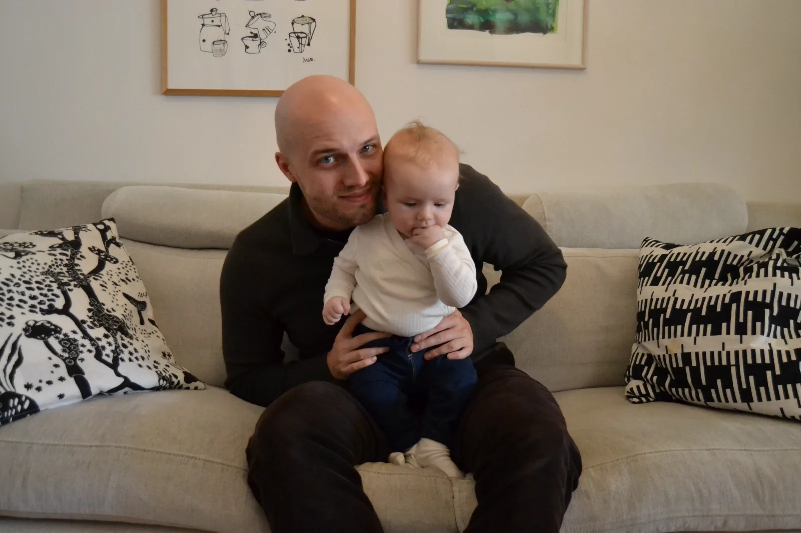 The founder seated on a sofa with his young child.